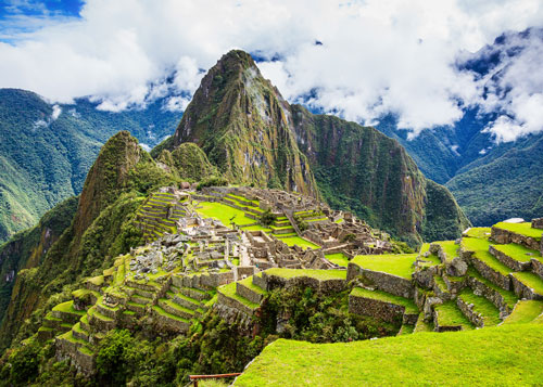 Mountains and ruins in Peru's elevations with clouds touching the mountains